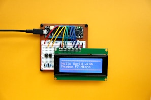 an electronic device with a blue screen on a yellow surface