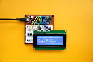 an electronic device with a blue screen on a yellow surface