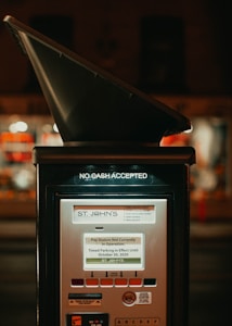 A parking pay station with a sign indicating that no cash is accepted. The screen displays a message stating that the pay station is currently not in operation and timed parking is in effect until October 30, 2020. Various buttons and informational markings are visible on the pay station.