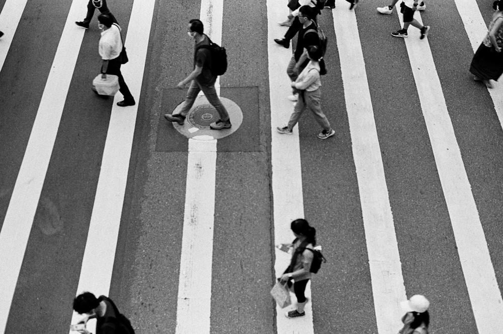 people walking on pedestrian lane in grayscale photography