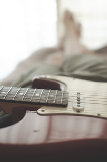 A close-up of a guitar resting on a stool.