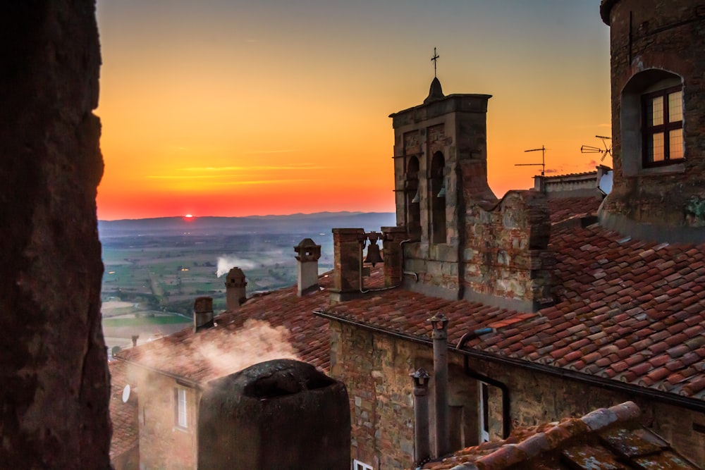 brown brick building near sea during sunset