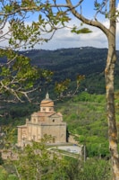 Historic architecture of an ancient church nestled among lush greenery.