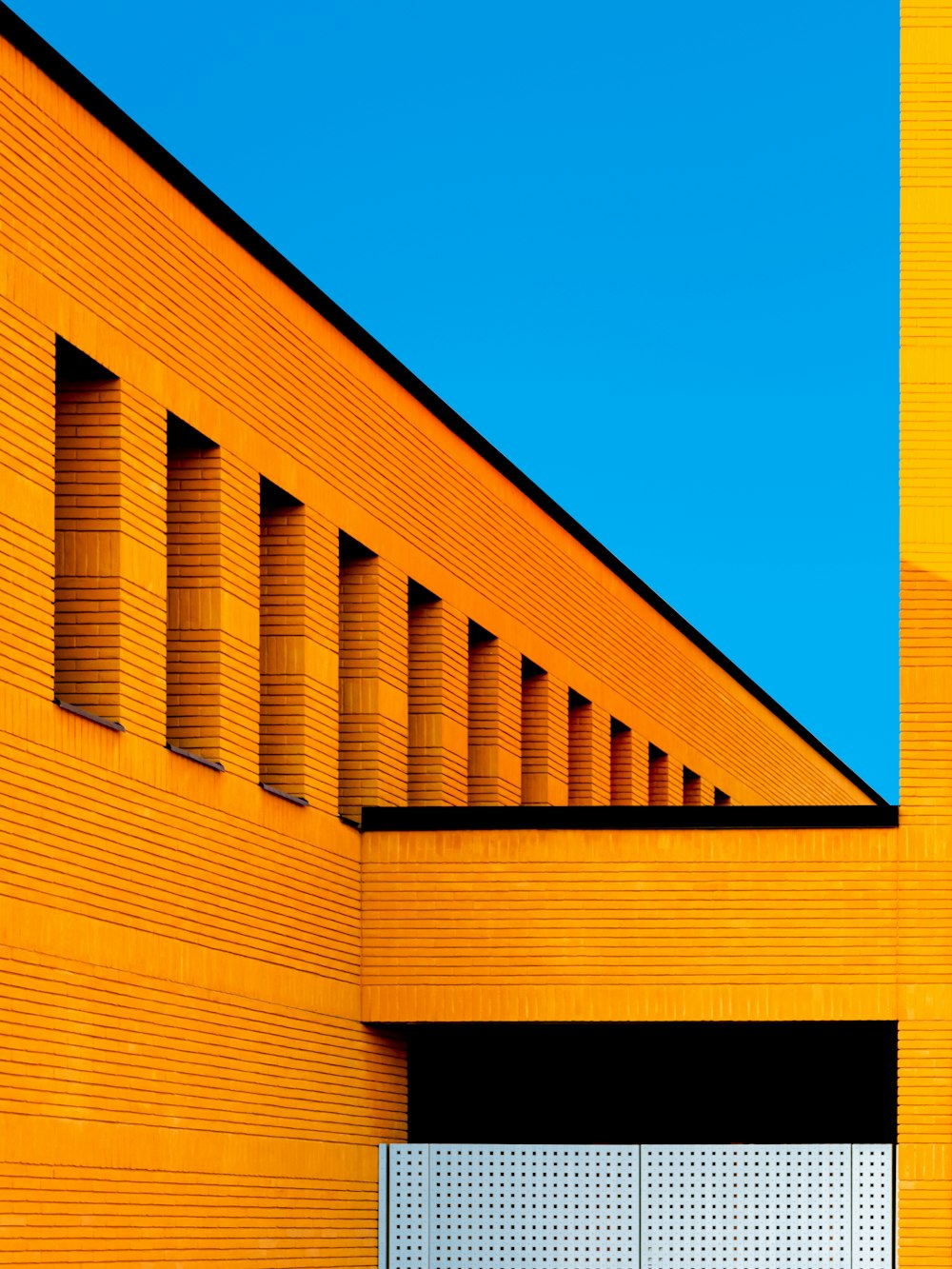 Braunes Betongebäude unter blauem Himmel tagsüber