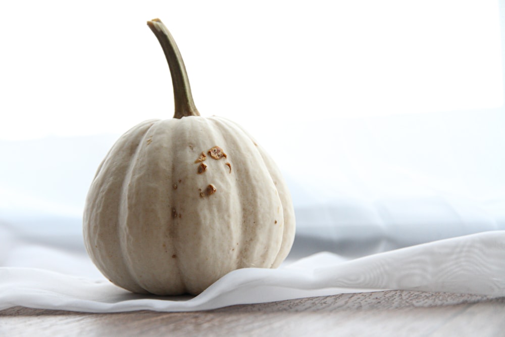 white pumpkin on white textile