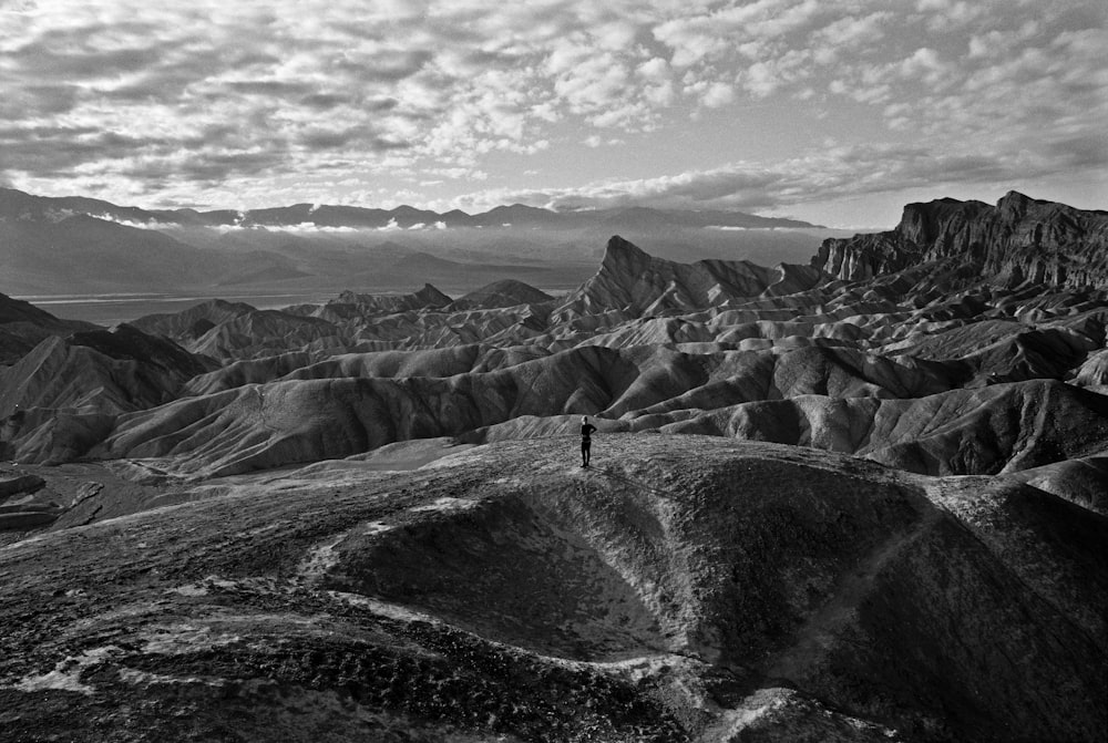 person in black jacket standing on gray rock formation during daytime