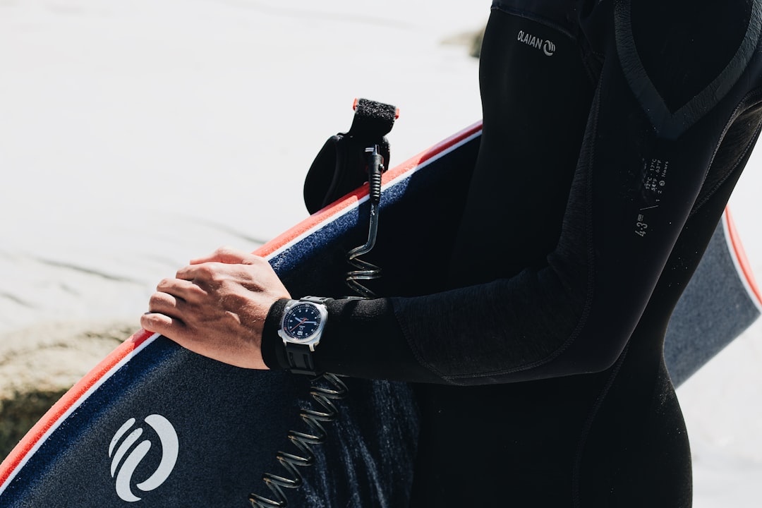 person in black jacket holding blue and black bag