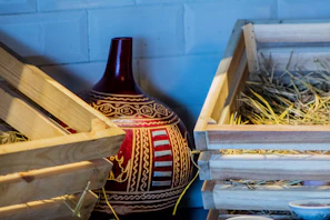 Colorful hand-painted ceramic vase resting on a rustic wooden table