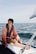 man in red jacket sitting on boat during daytime