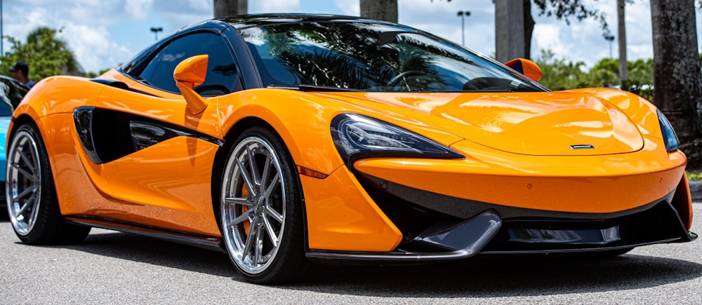 orange lamborghini aventador parked on gray asphalt road during daytime