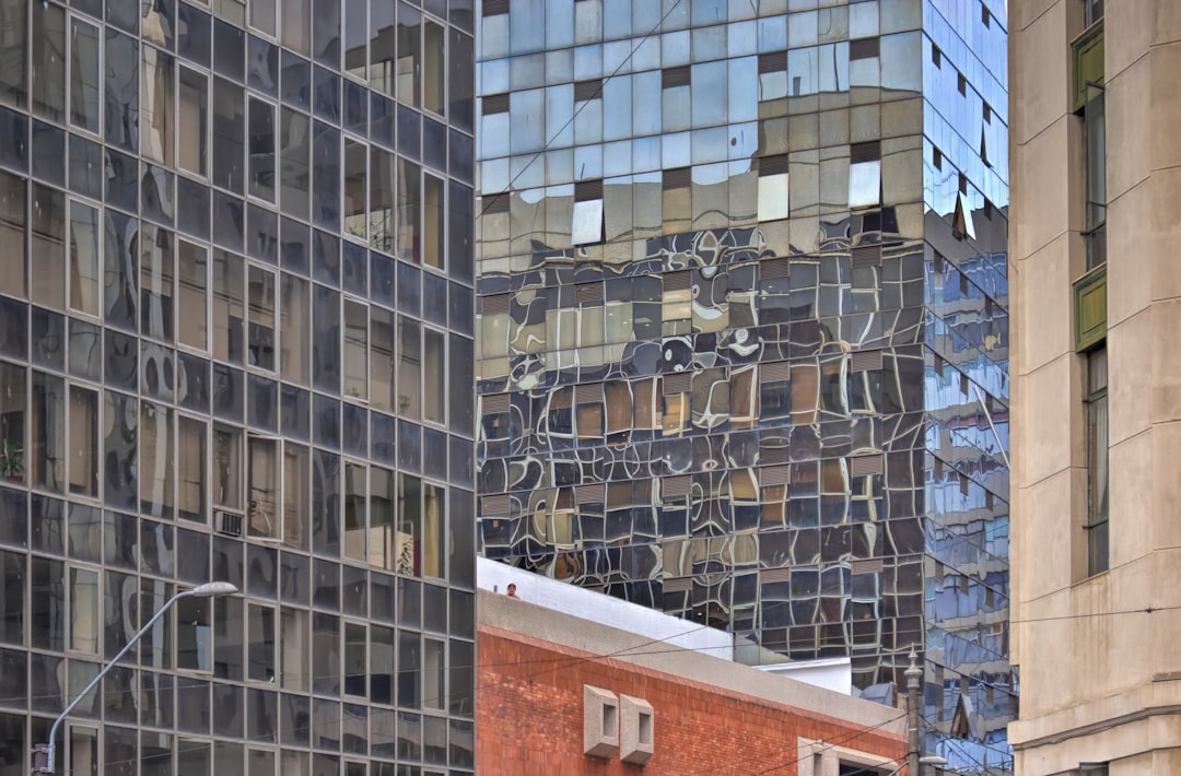 black and white cars parked beside brown and white concrete building during daytime