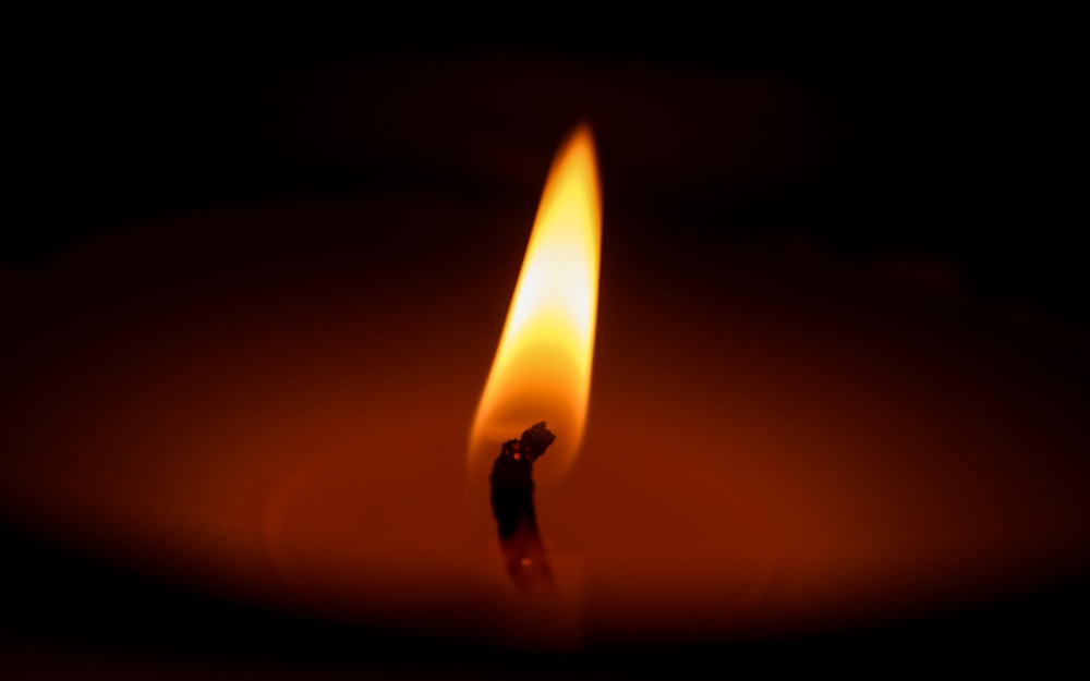 lighted candle in dark room