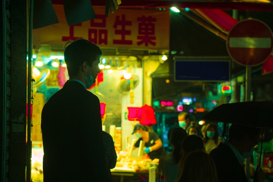 man in black suit standing in front of people during nighttime