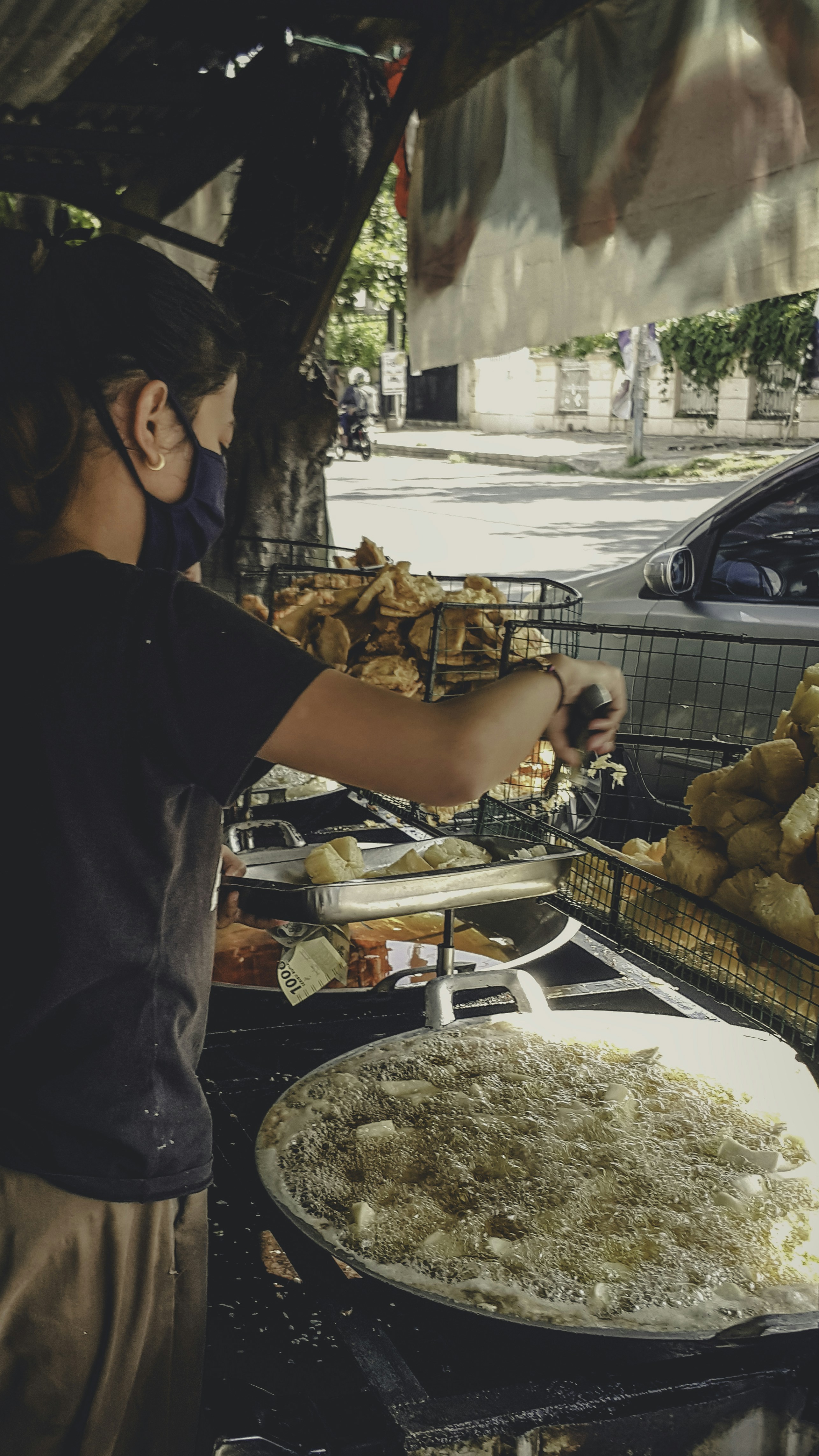 Crispy golden snacks in a dark iron kadhai, low key dramatic lighting, street food vendor