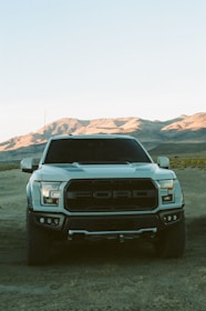 white chevrolet car on dirt road during daytime