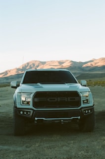 white ford car on dirt road during daytime
