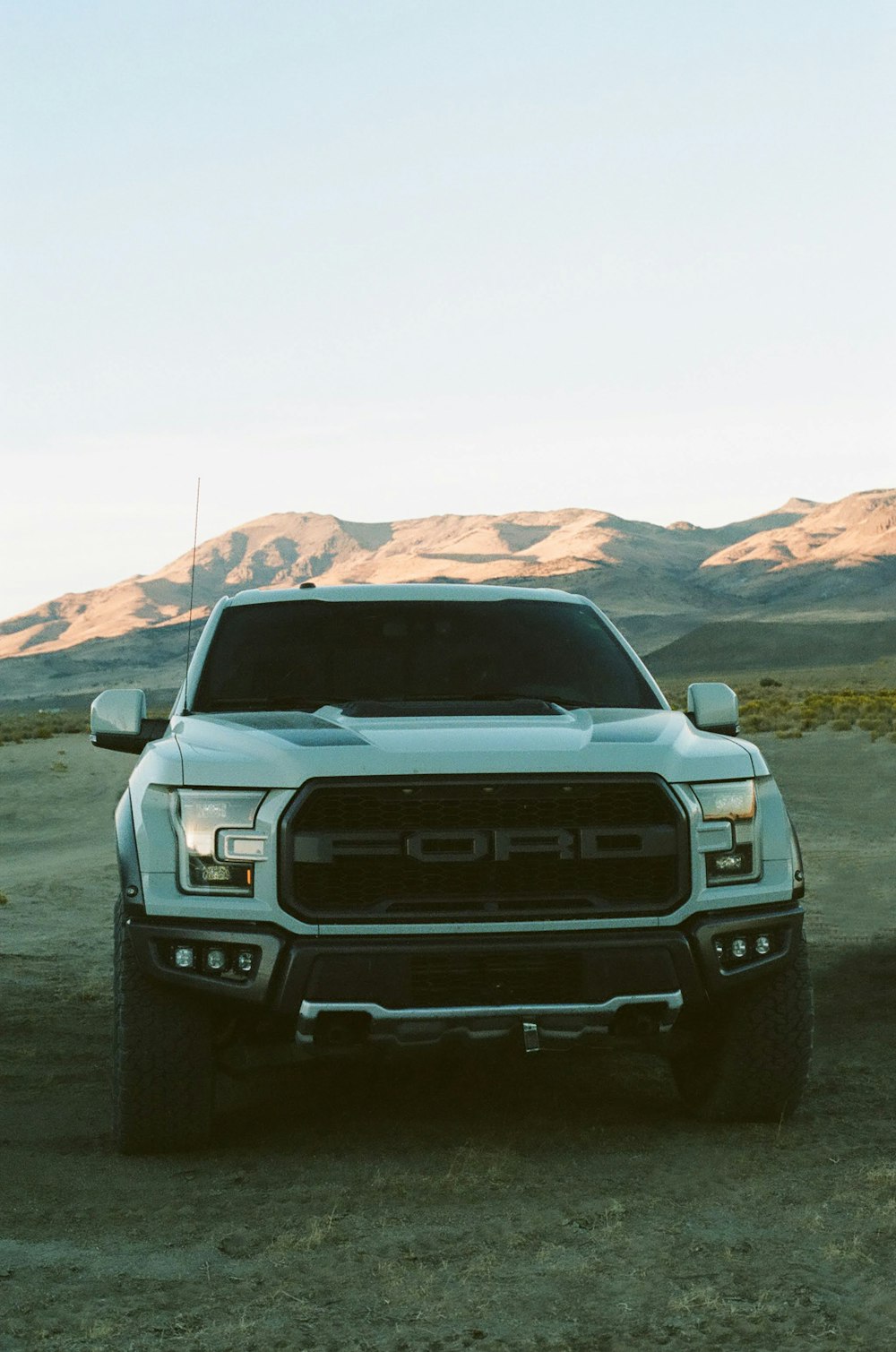 white chevrolet car on dirt road during daytime