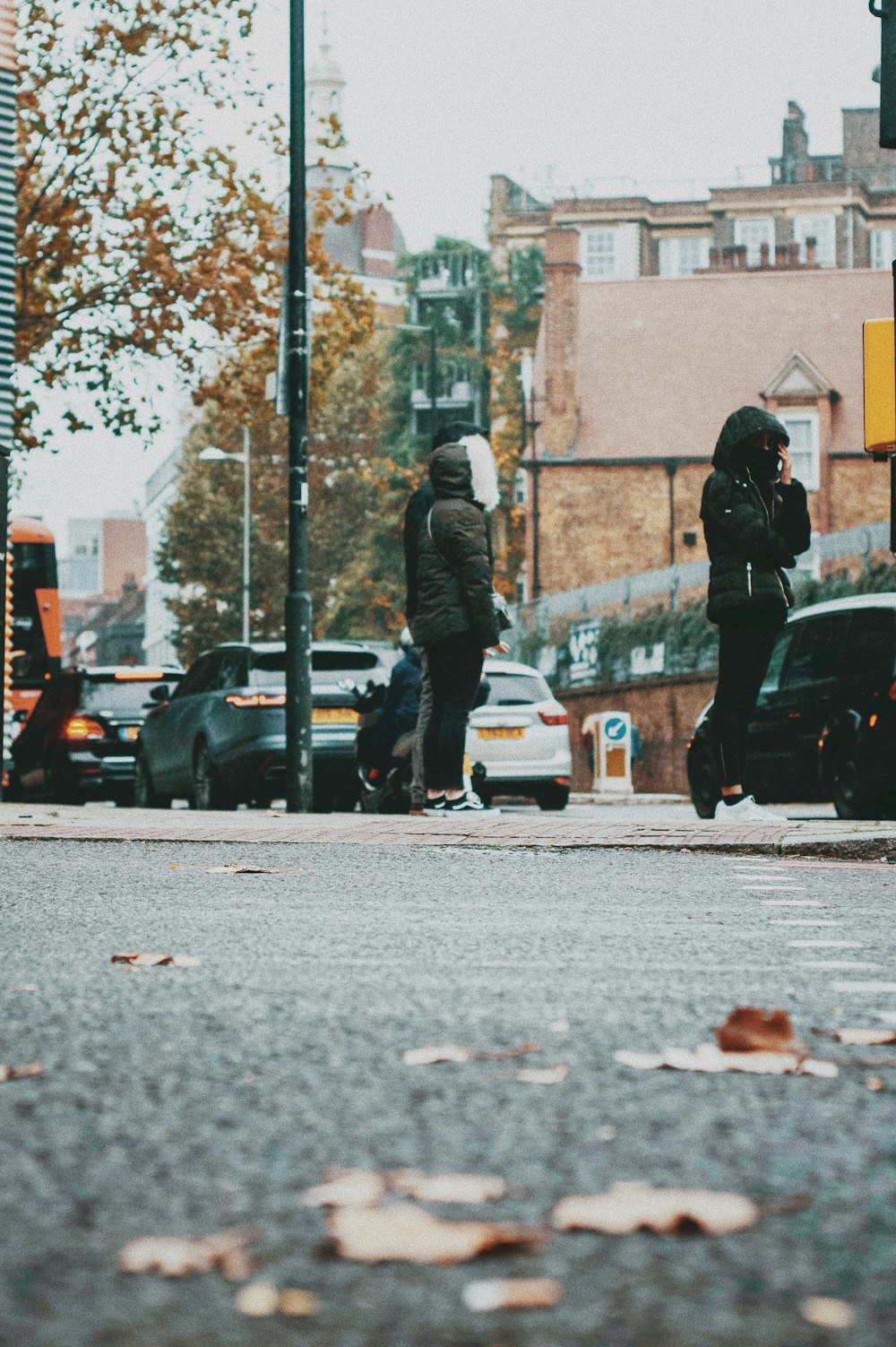Mann in schwarzer Jacke und schwarzer Hose geht tagsüber auf dem Bürgersteig spazieren