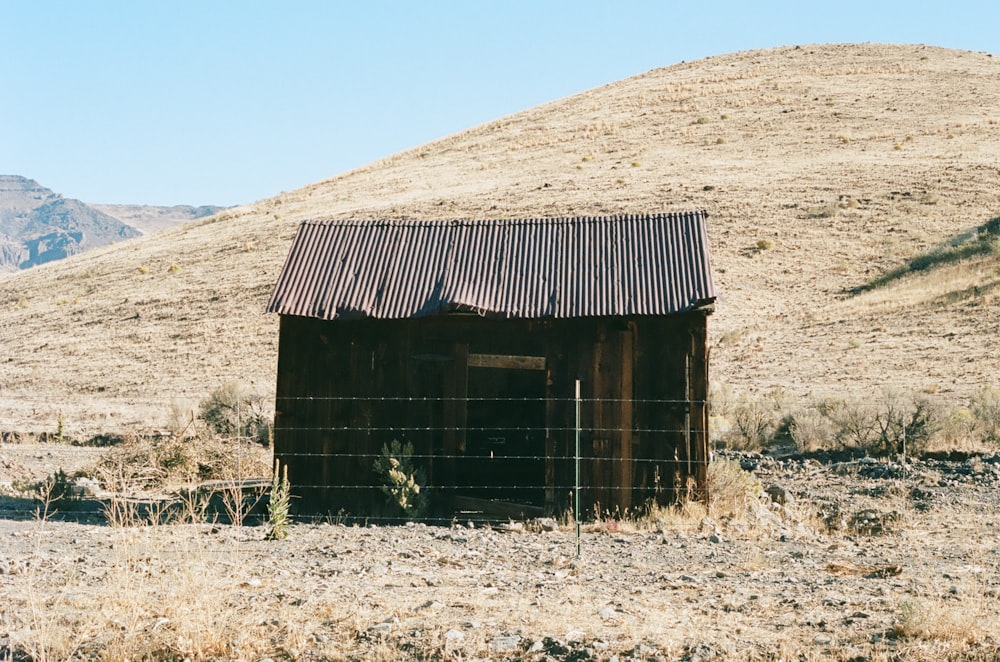 brown wooden house on brown field during daytime