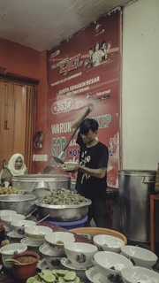 man in black and red crew neck t-shirt holding chopsticks