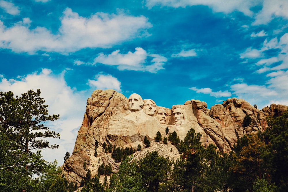 brown rock formation under blue sky and white clouds during daytime