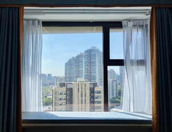 A modern downtown condo with large windows showcasing a city skyline view.