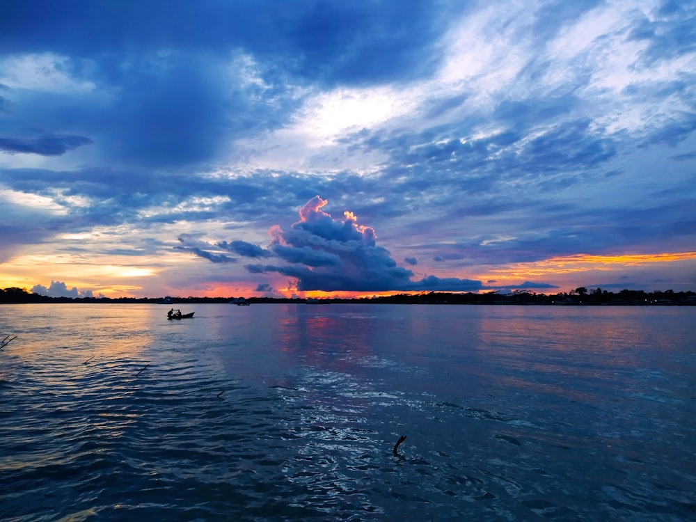 Gewässer unter blauem Himmel und weißen Wolken tagsüber