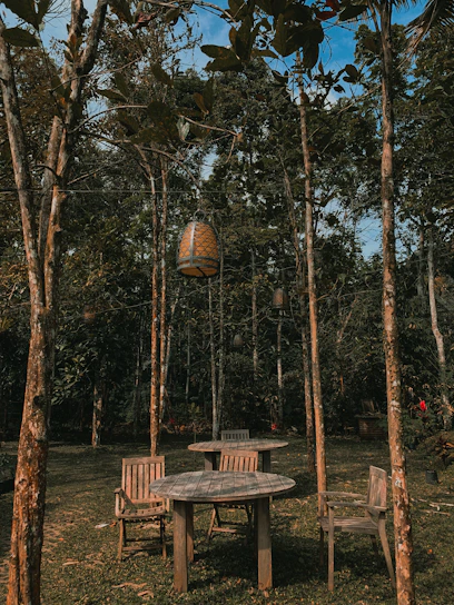 A serene outdoor setting with a long wooden table surrounded by softly glowing lanterns under a twilight sky.