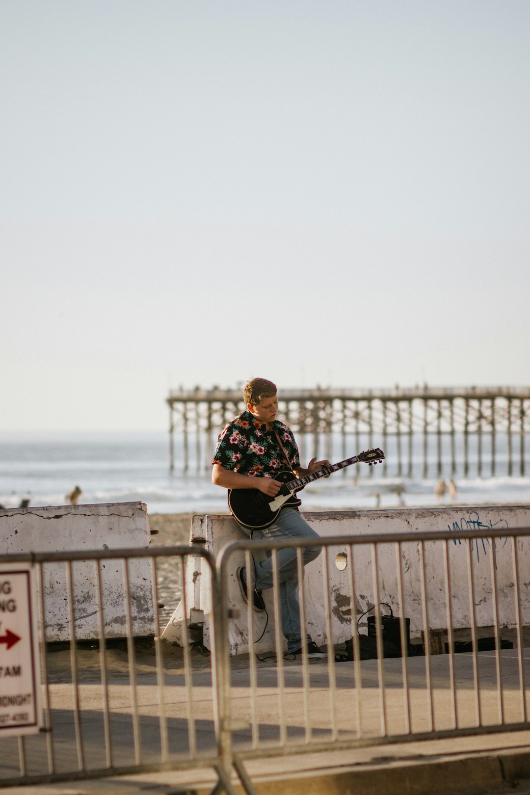 man in black and white long sleeve shirt playing guitar