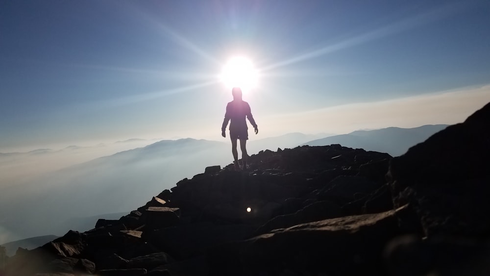 man standing on rock formation during daytime