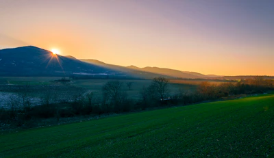 A sunrise over a thriving landscape representing growth and positive change.