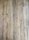 A close-up view of wooden floorboards with a natural, rustic appearance. Each plank has unique grain patterns and knots, with variations in color and texture that add character.