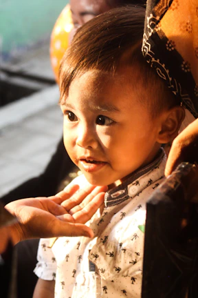 A close-up of a child gently holding a soft, textured sensory ball, sunlight streaming in.