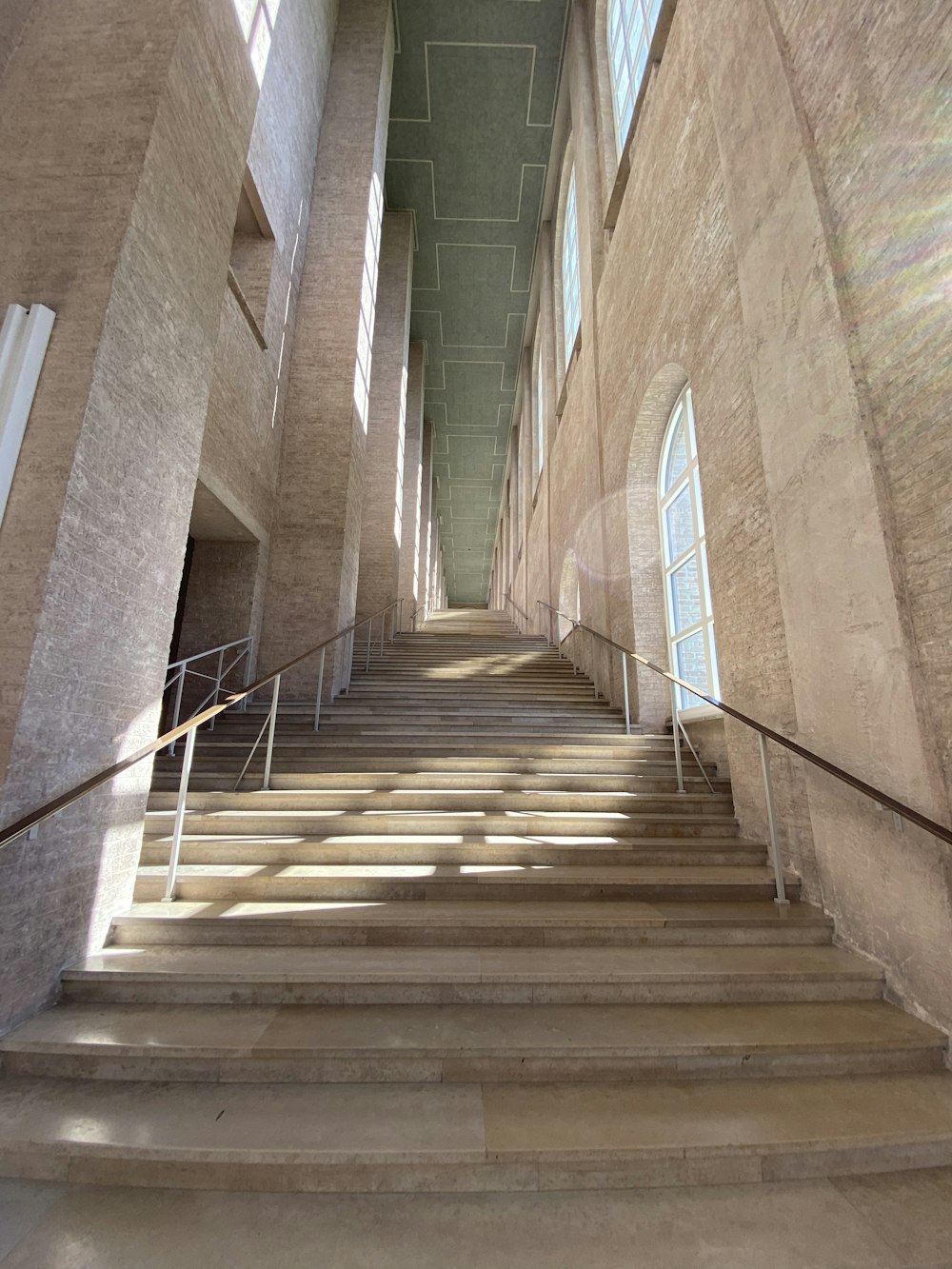 brown wooden staircase in between blue concrete walls