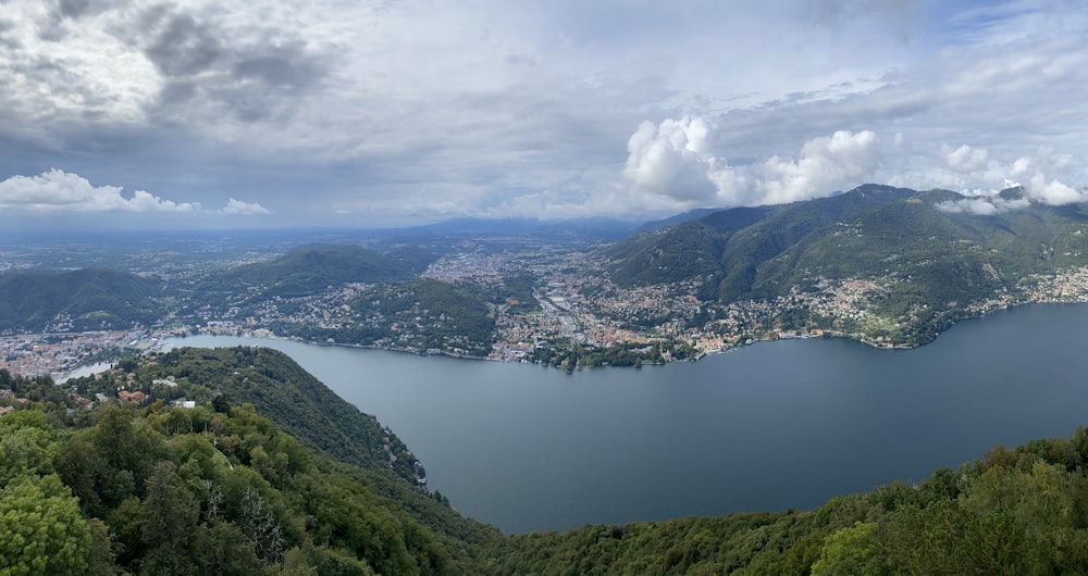 aerial view of green mountains and river under cloudy sky during daytime