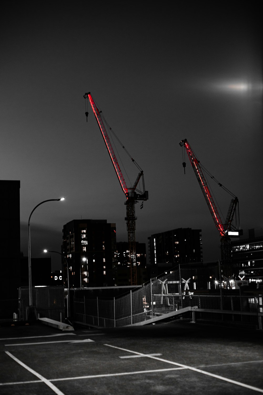 red and black crane near building during night time
