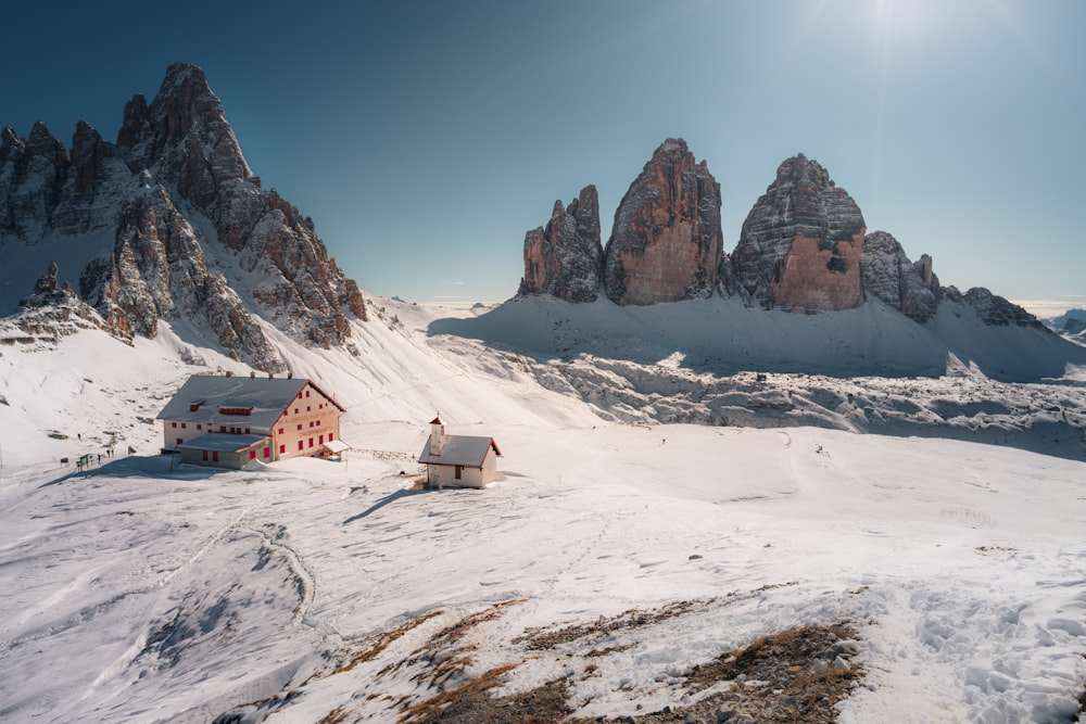 casa marrone e bianca sul campo coperto di neve bianca durante il giorno