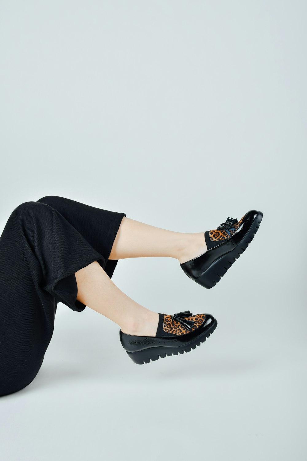 Frau in schwarzer Hose in schwarzem Leder Peep Toe Heeled Schuhe