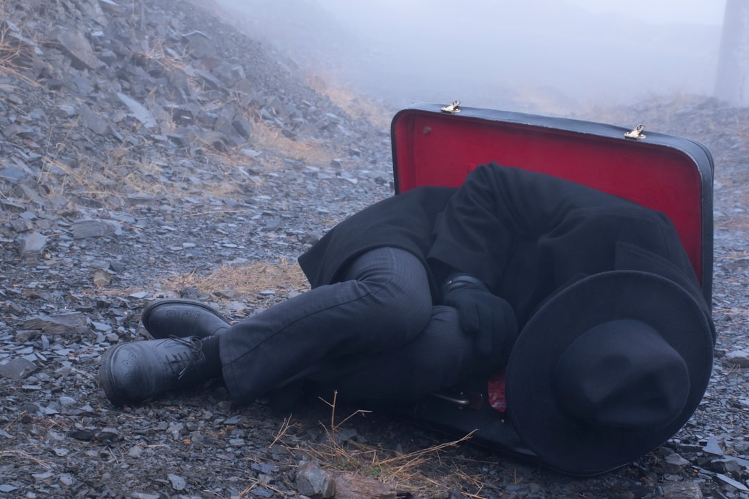 man in black jacket and black pants sitting on red chair