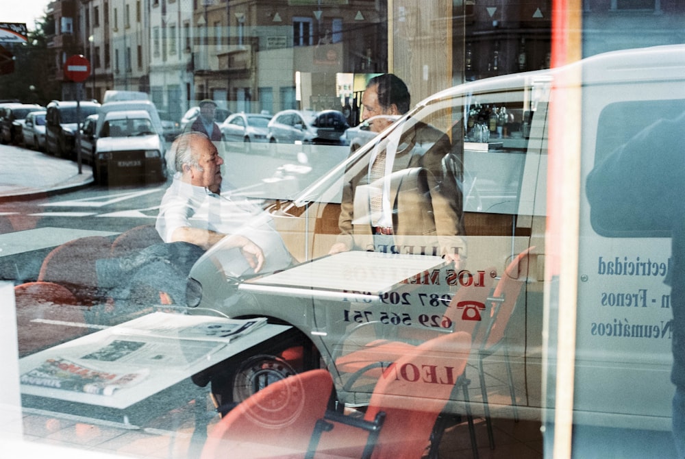 man in white dress shirt sitting on red chair