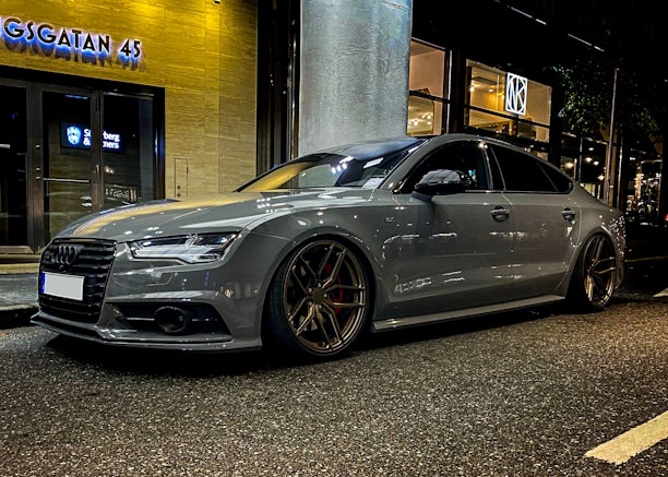 Side view of a sleek car with freshly tinted windows reflecting a cityscape at dusk.