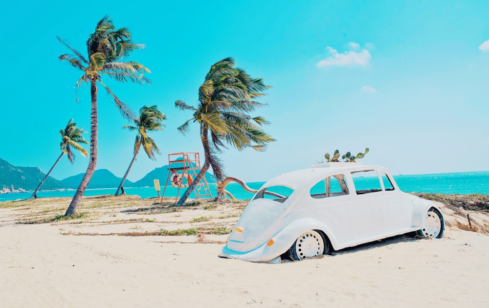 white volkswagen beetle on beach during daytime