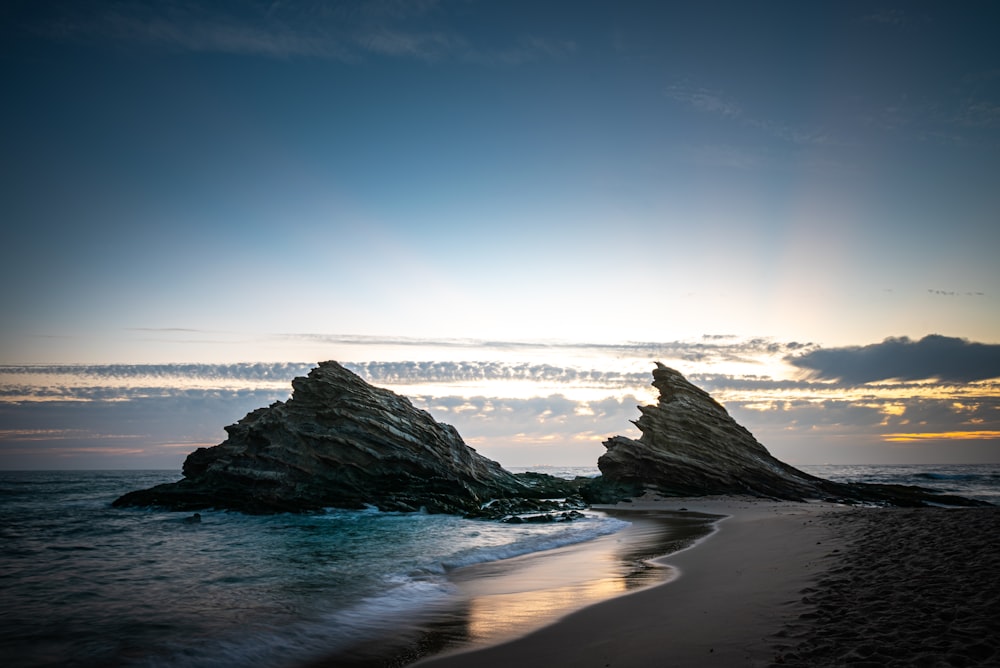 Formation de roche noire sur le bord de la mer pendant la journée