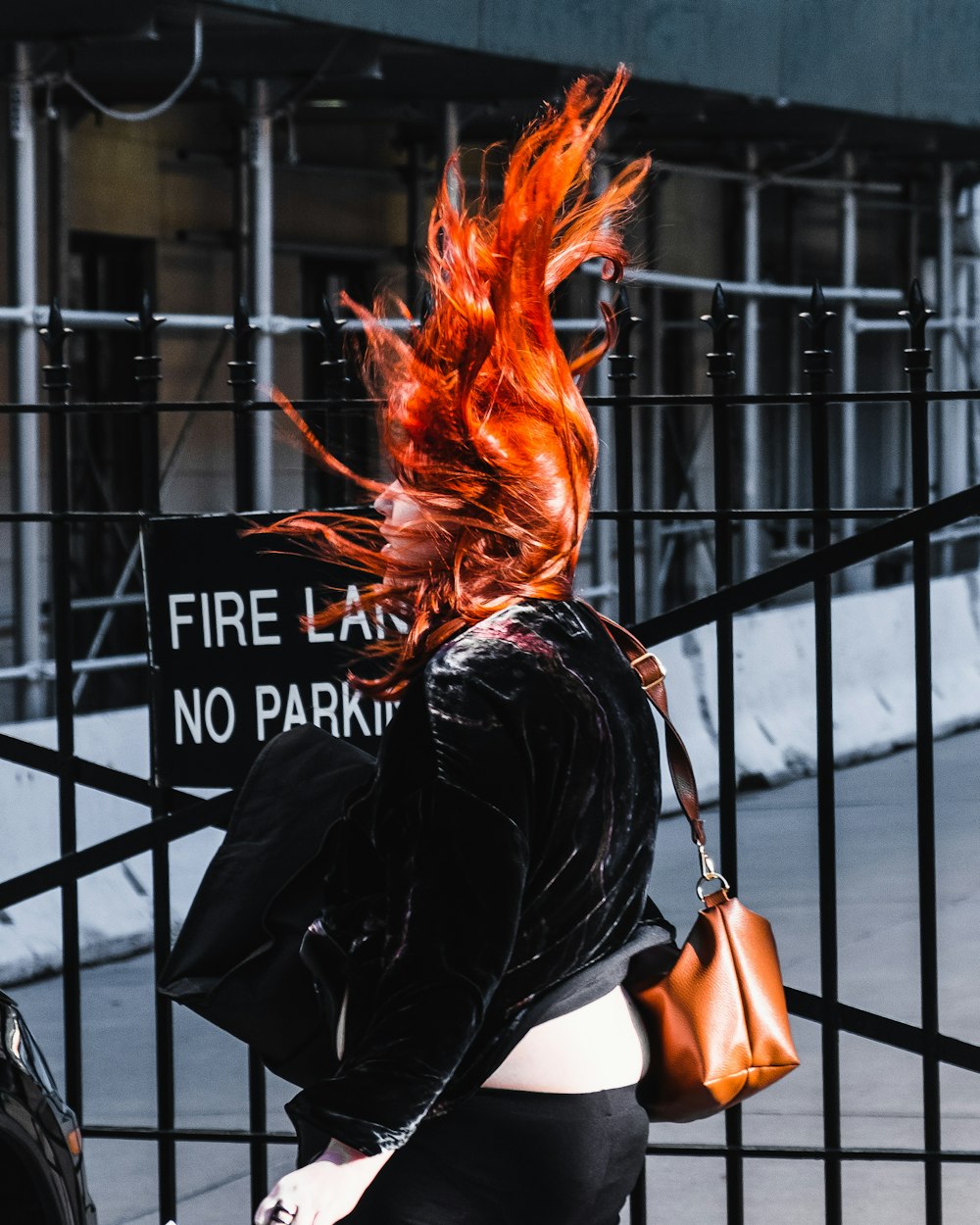 woman in black shirt standing near black metal fence