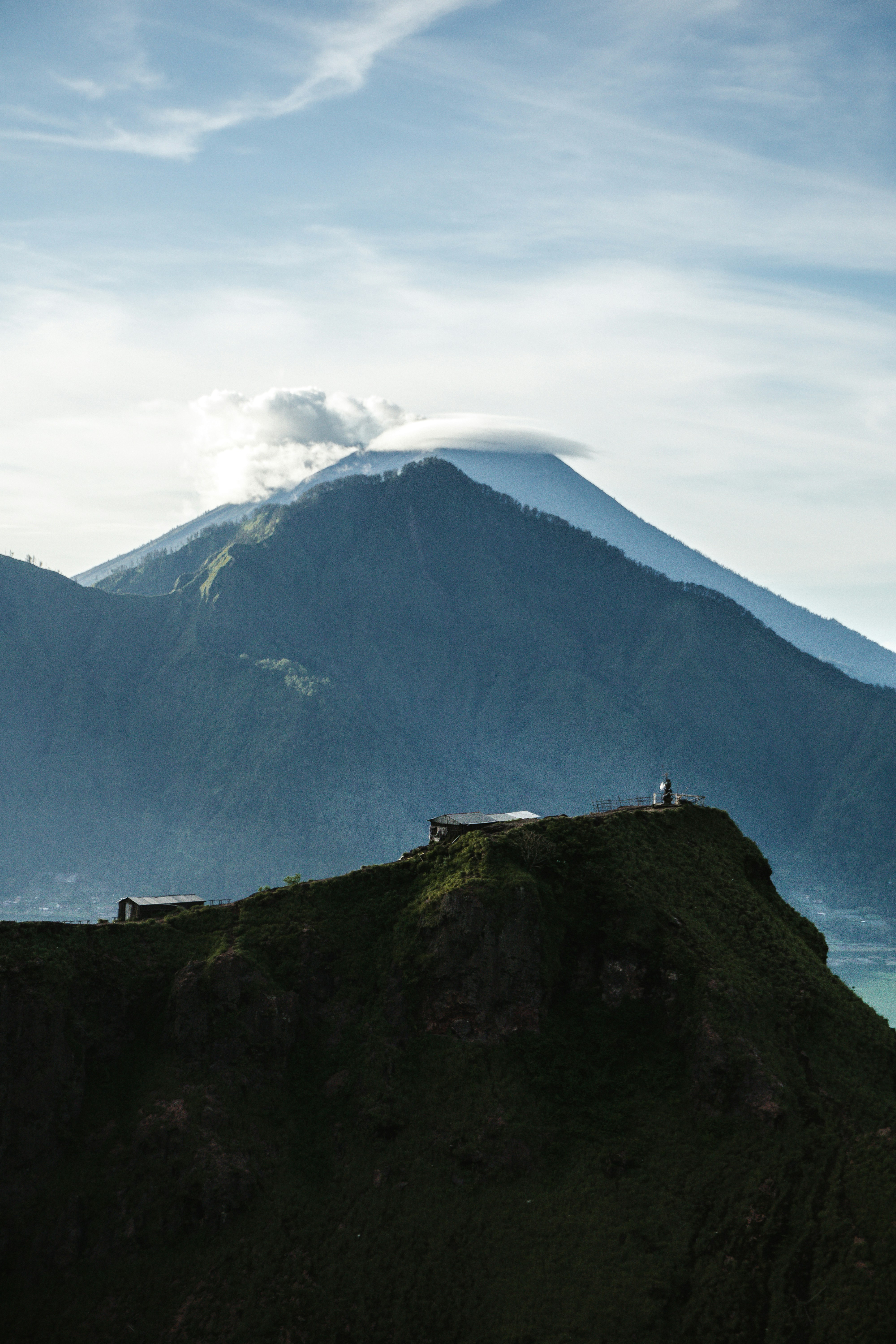 orang yang berdiri di puncak gunung pada siang hari