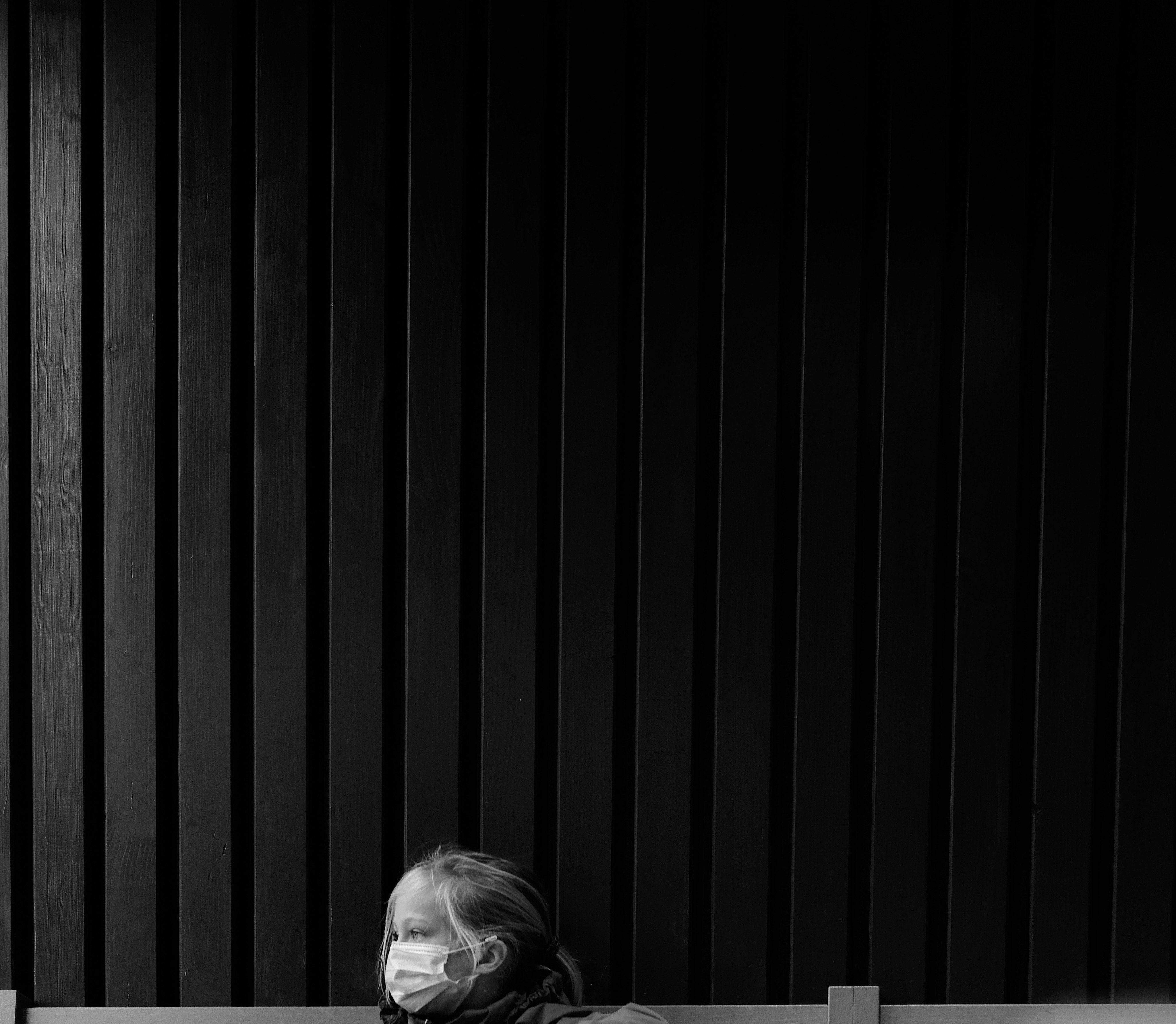 woman in black jacket standing beside black and white striped wall