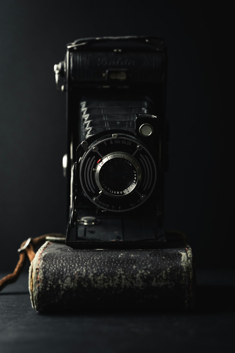 black and silver camera on brown textile