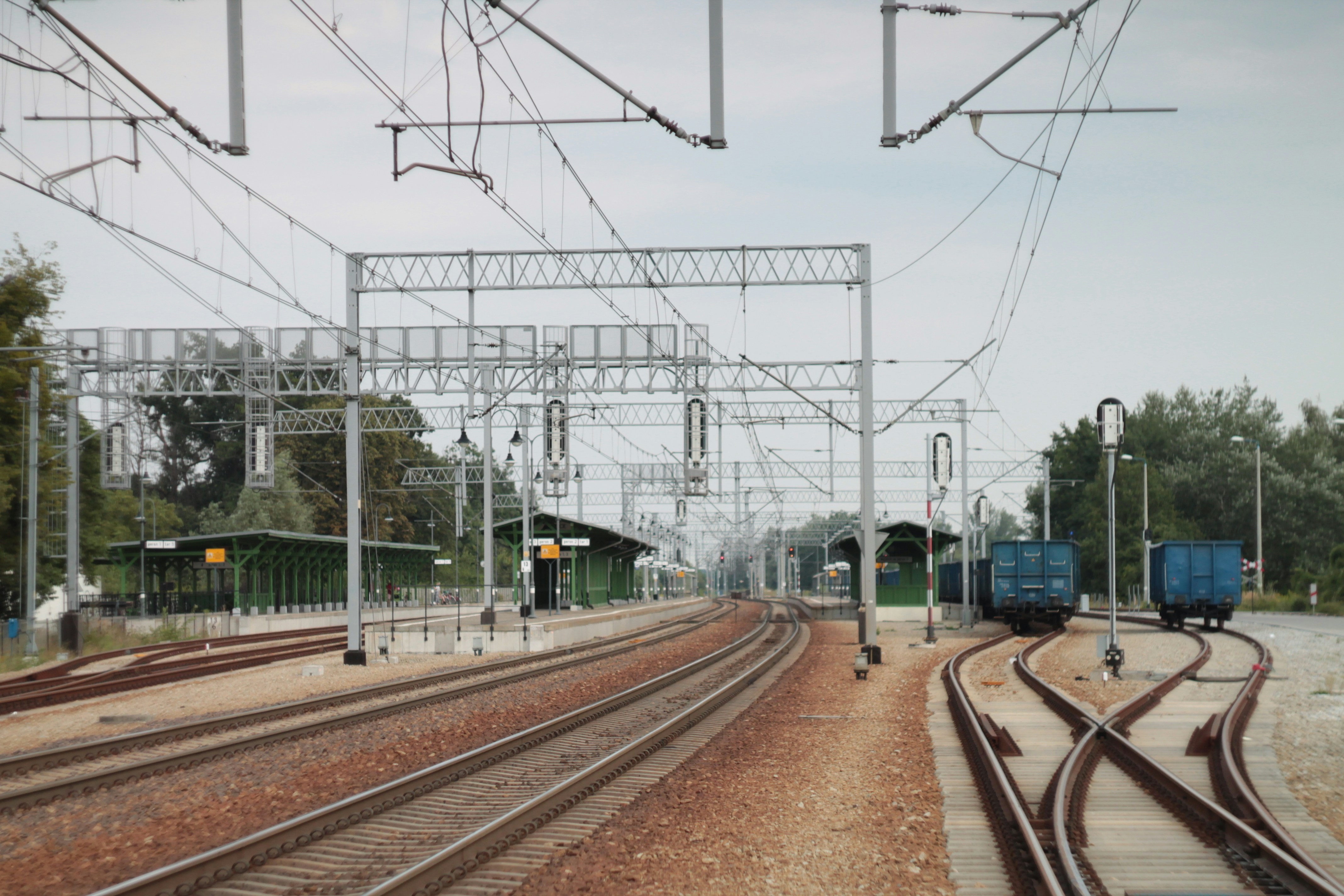 train rail near green trees during daytime