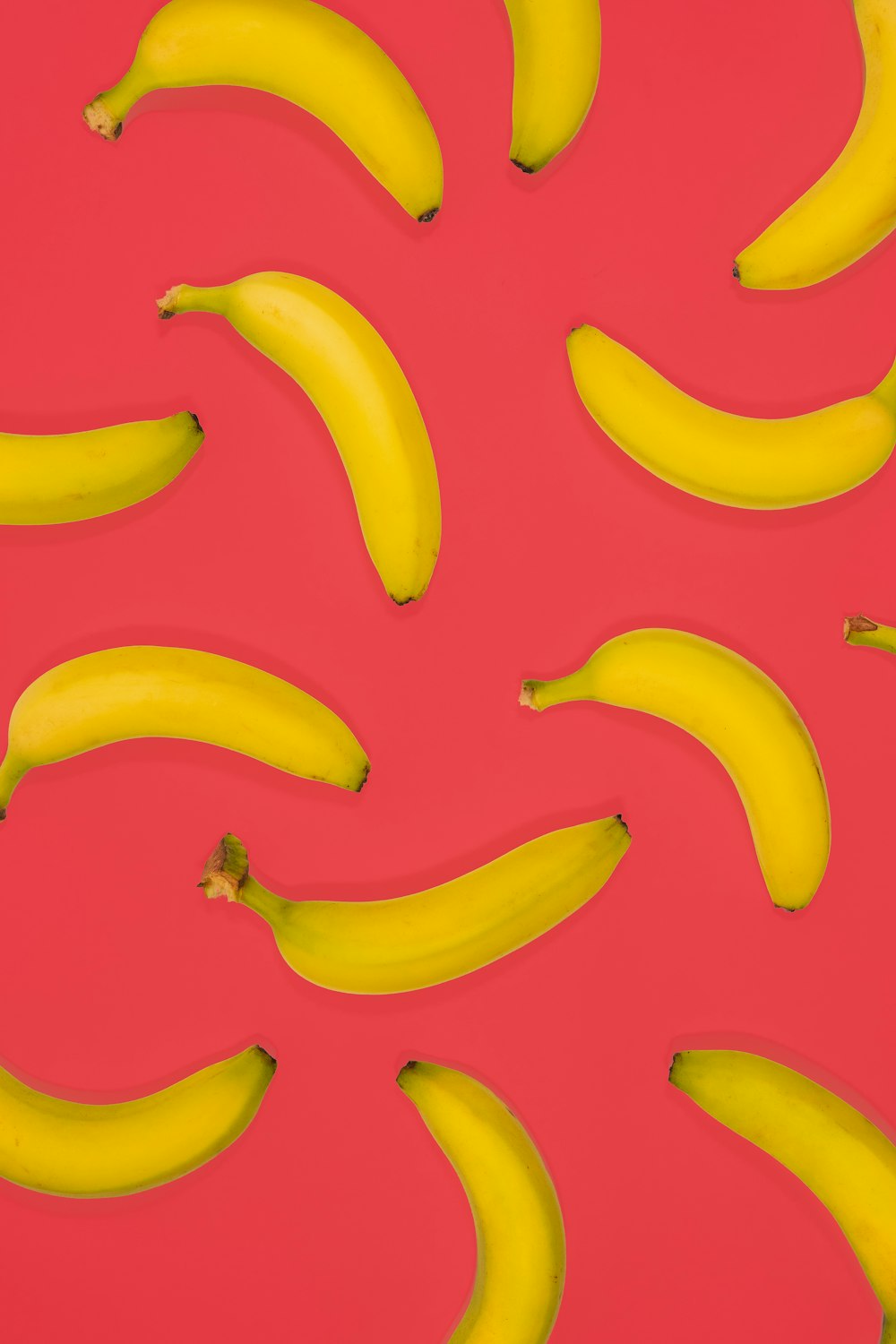 yellow banana fruits on pink surface