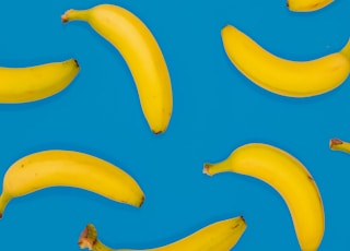 yellow banana fruits on blue surface